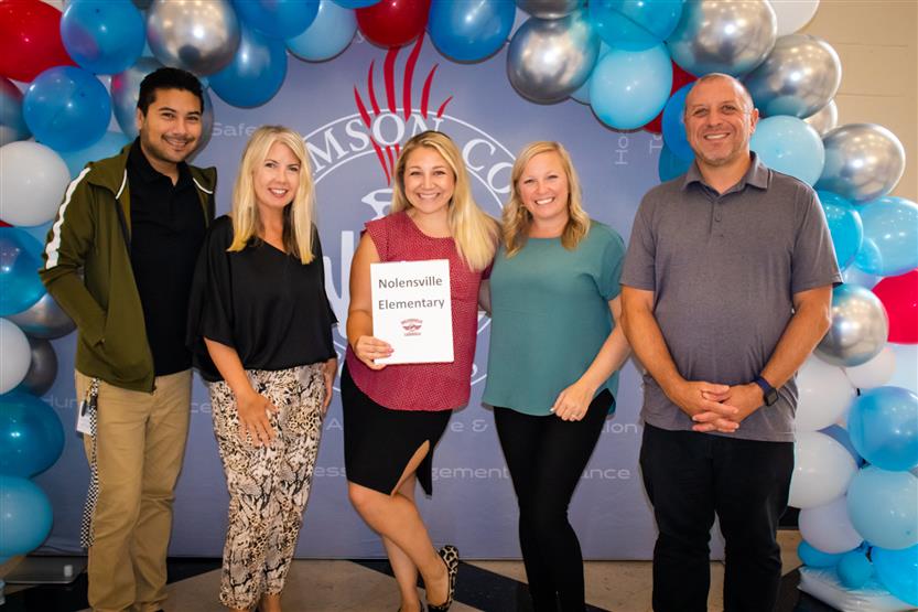 A group of teachers smile